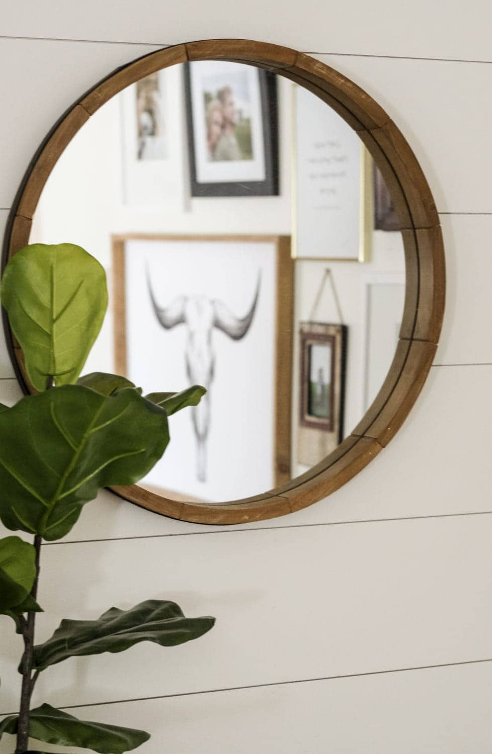 a living room mirror. The reflection of a gallery wall is visible 