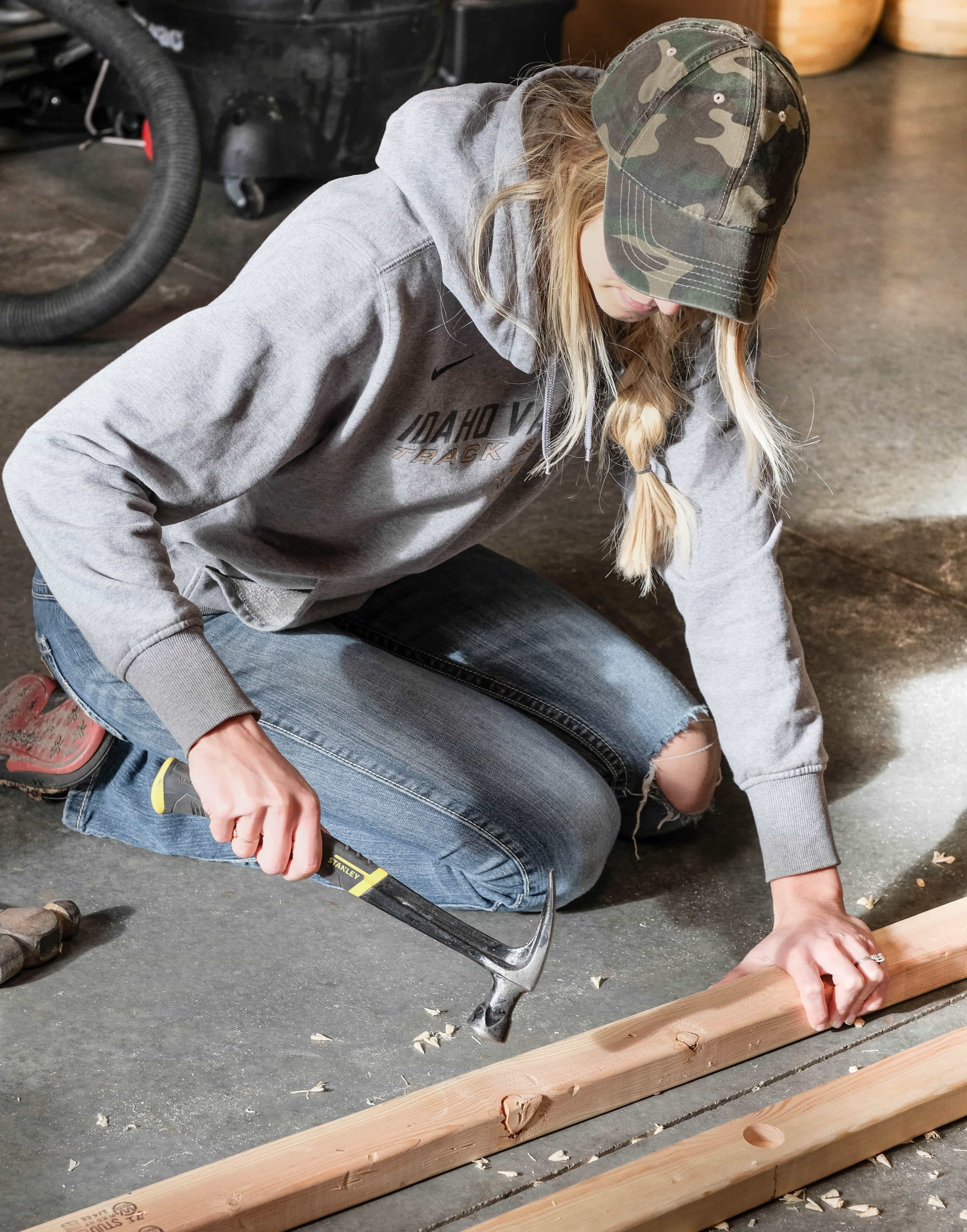 A woman distressing a board for a blanket ladder