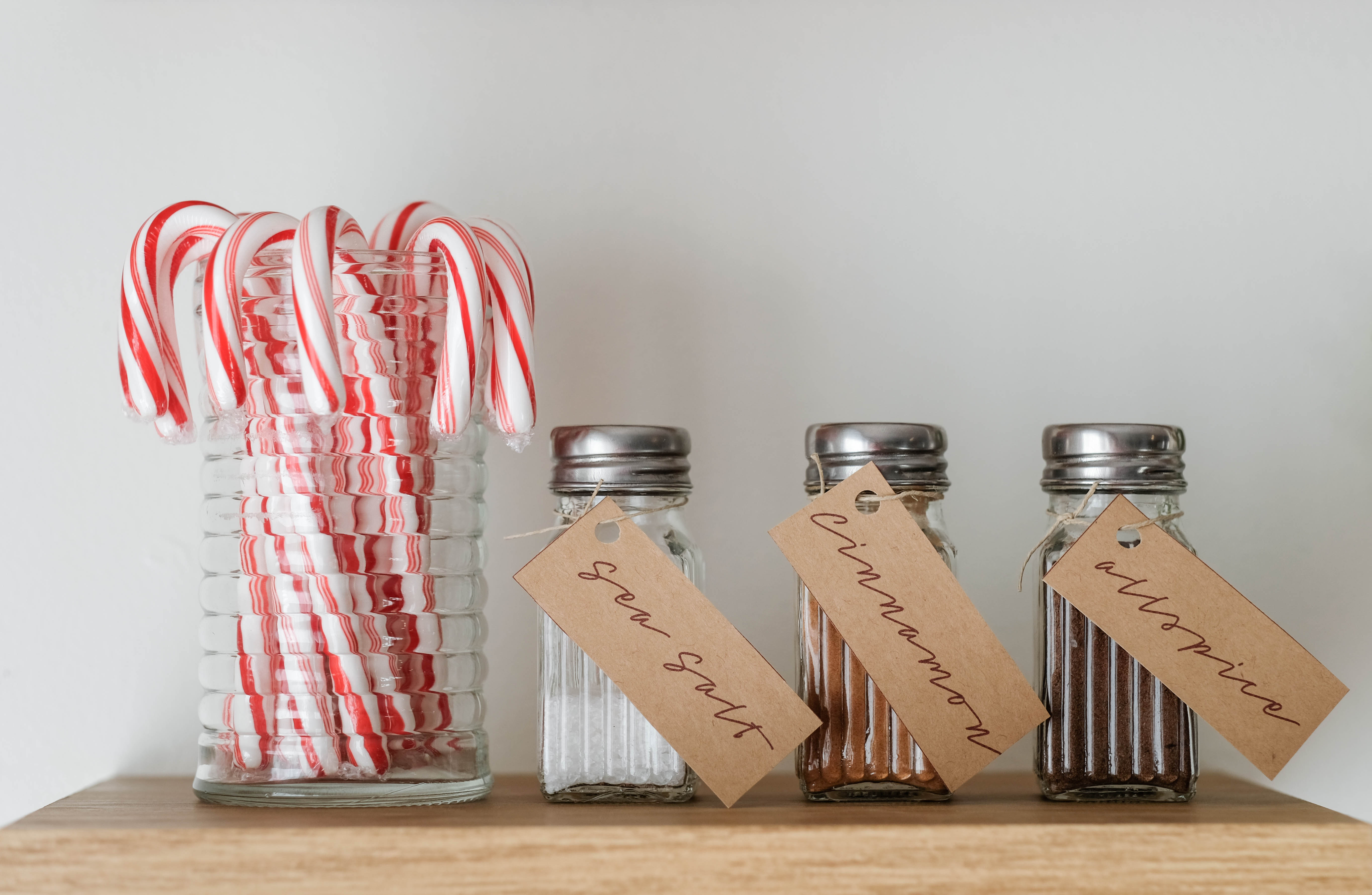 Candy Canes in a jar with shakers of sea salt, cinnamon, and allspice