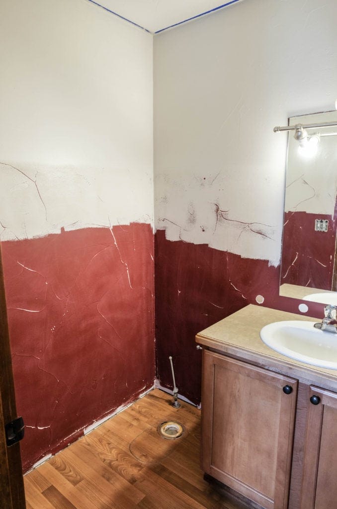 A halfbath in the middle of being painted and sanded in order to apply wallpaper