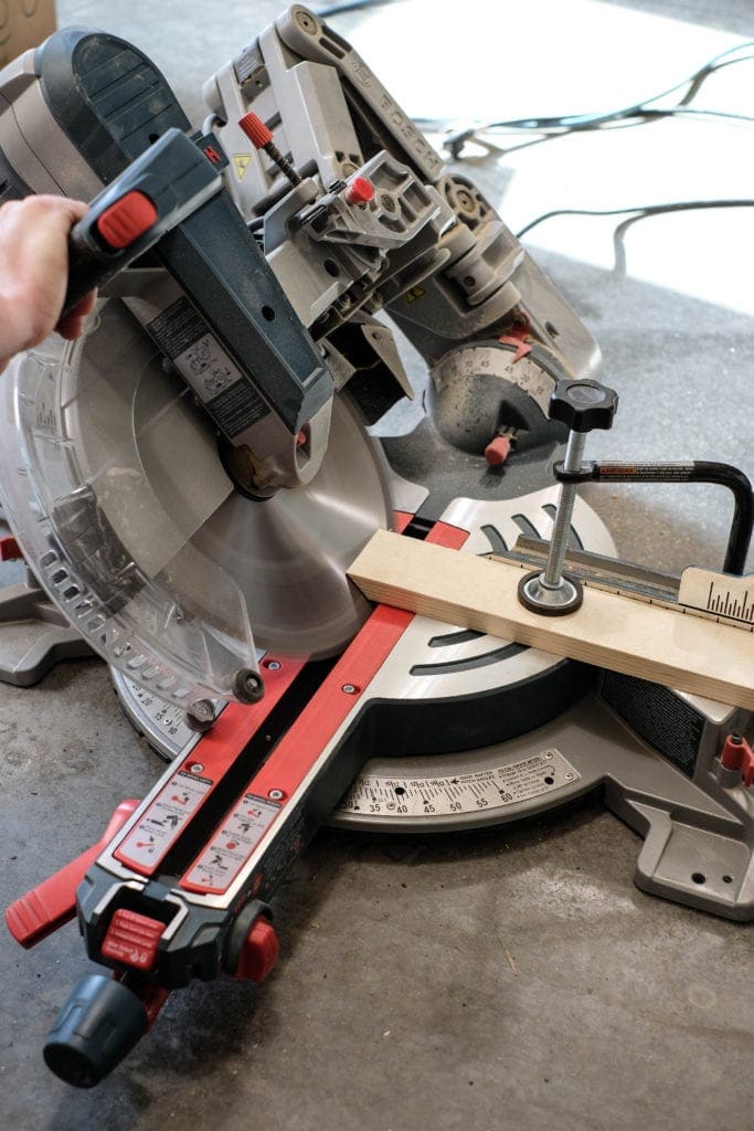 Miter saw cutting a 1" x 3" pine board at a 45 degree angle