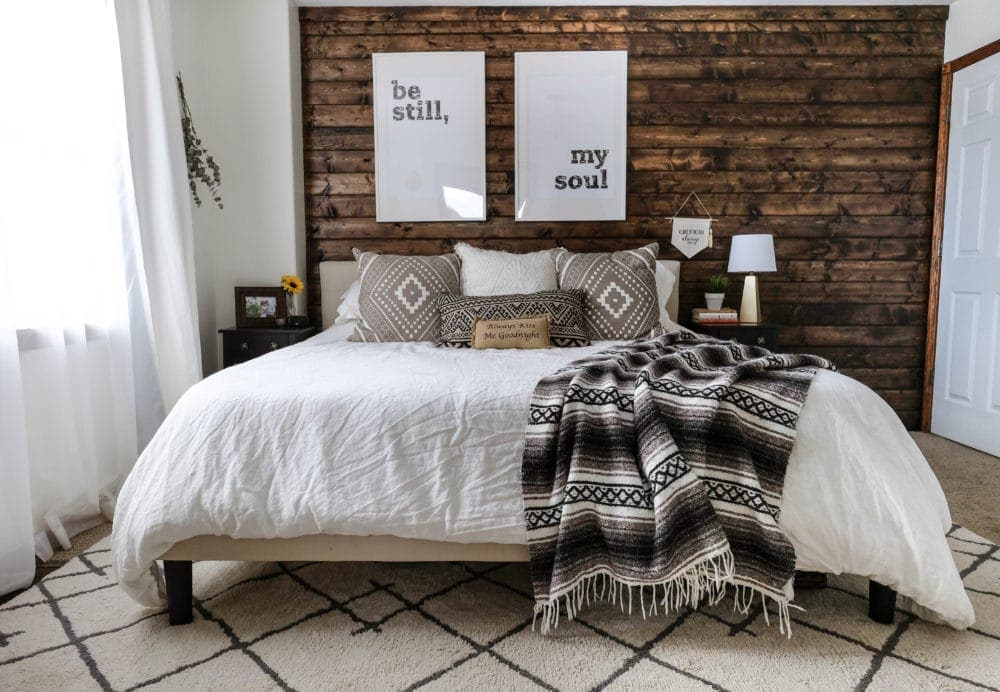 Decorated bedroom with a walnut stained DIY wood accent wall made of shiplap planks