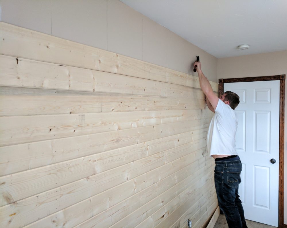 a man installing a DIY wood plank accent wall