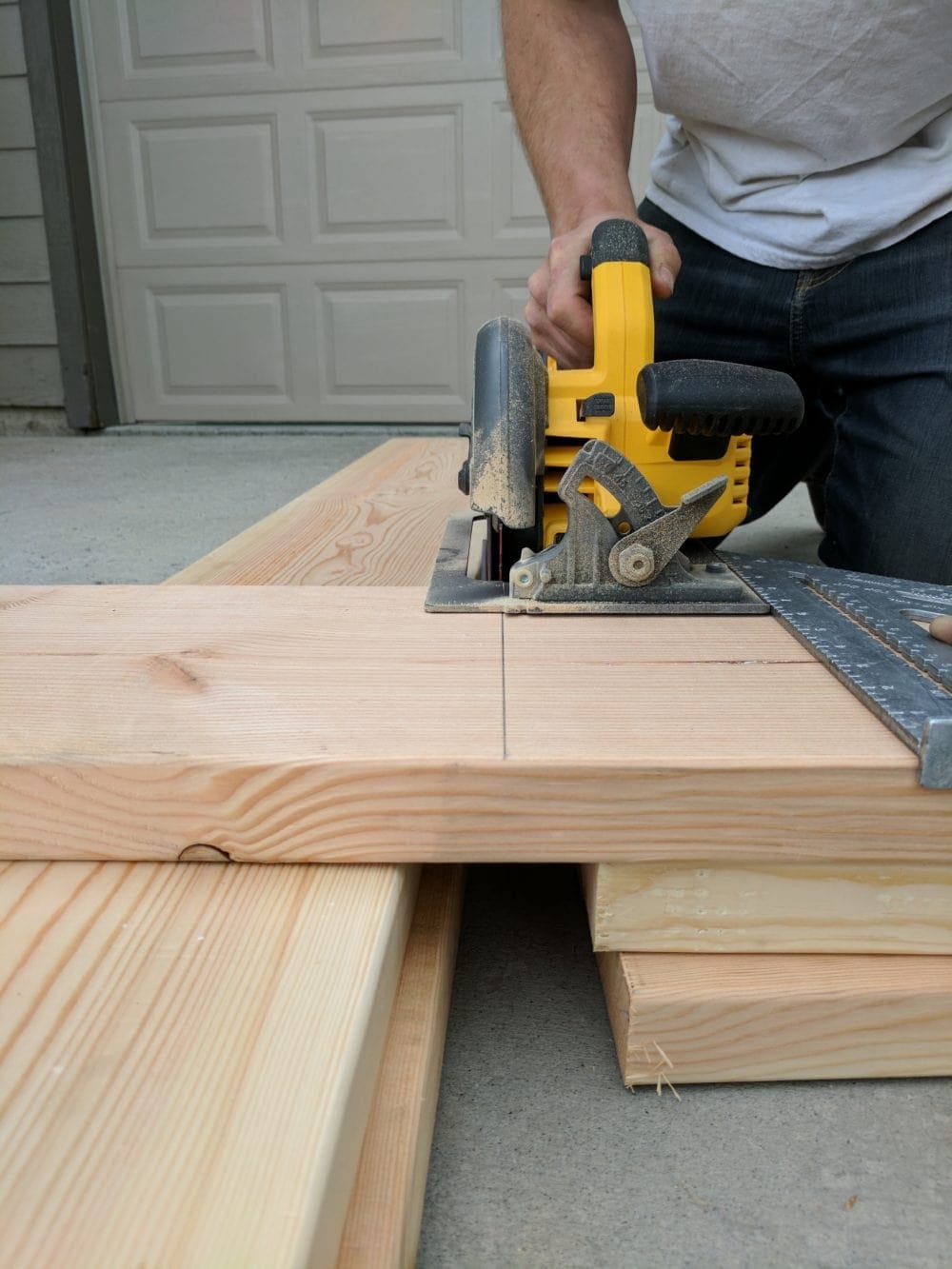 Man Using A Dewalt circular saw to cut a 2" x 10" board