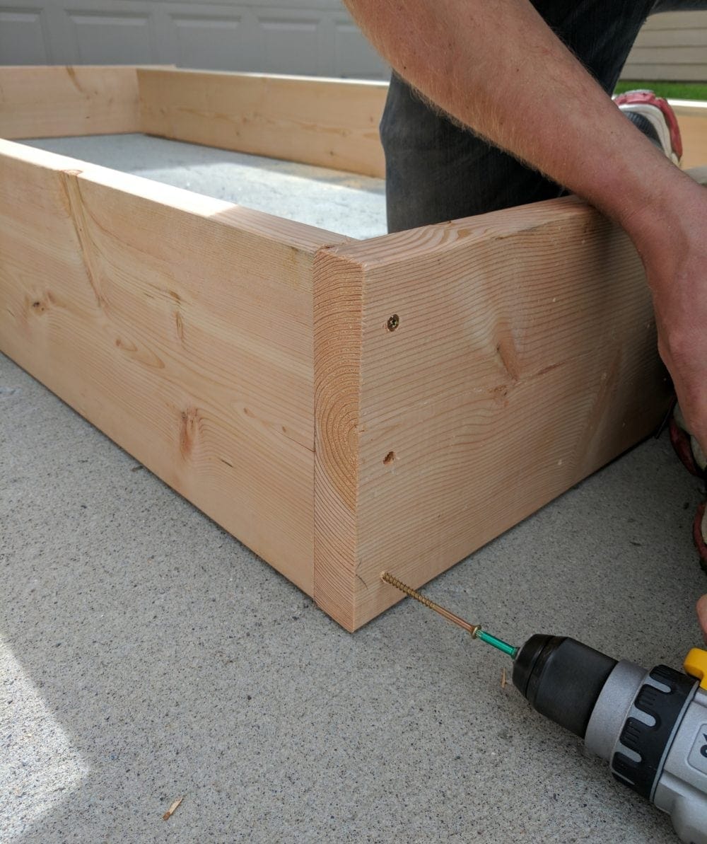 Assembling DIY Raised Garden Beds with a drill for a how to tutorial