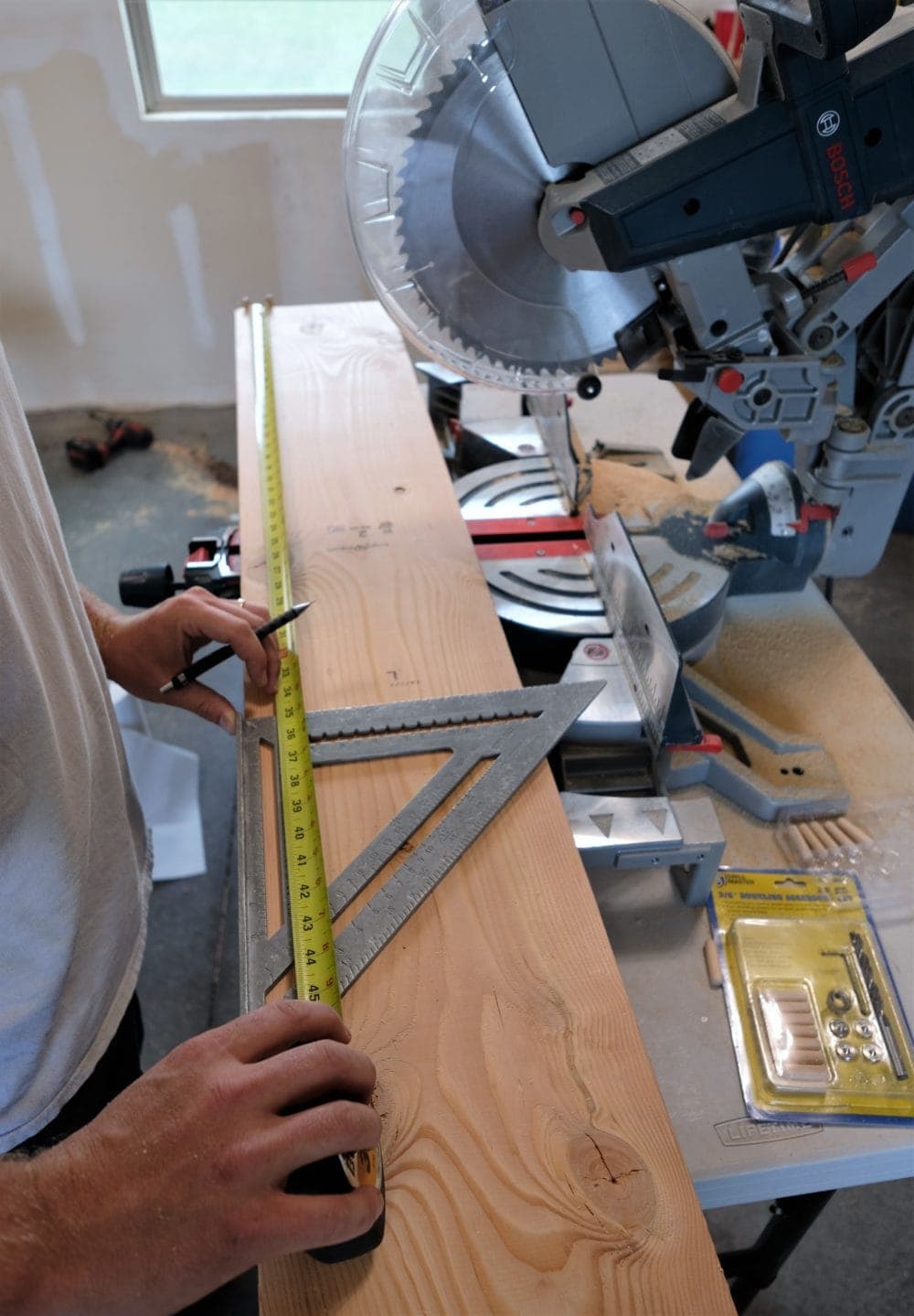 Man measuring a board to make rustic coffee table