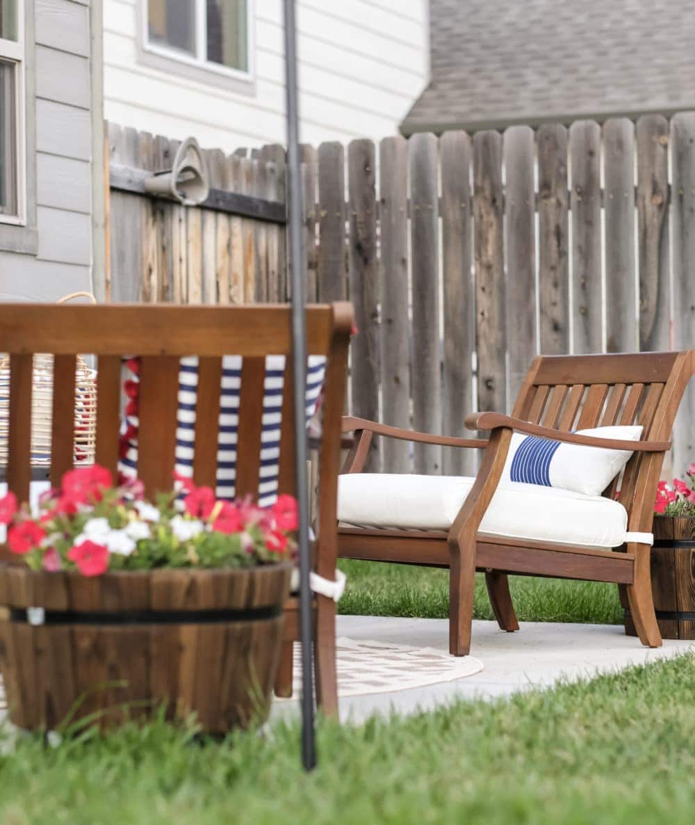 outdoor patio with flowers in barrels and wood lawn chairs