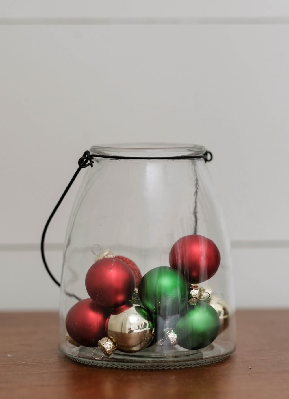 Christmas decor ideas using a glass lantern filled with mini ornaments