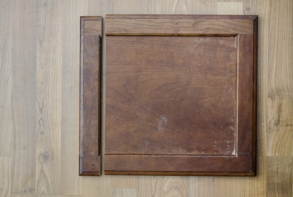 Cabinet door on ground with middle section removed to make it shorter for under an apron front farmhouse sink