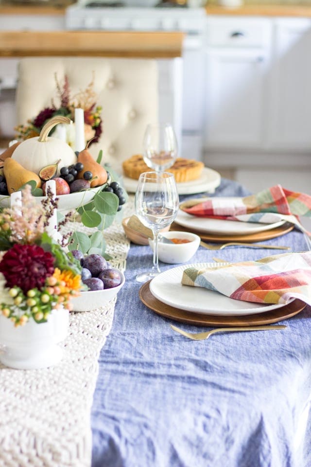 Thanksgiving table centerpieces with pumpkins and fruit and plaid napkins