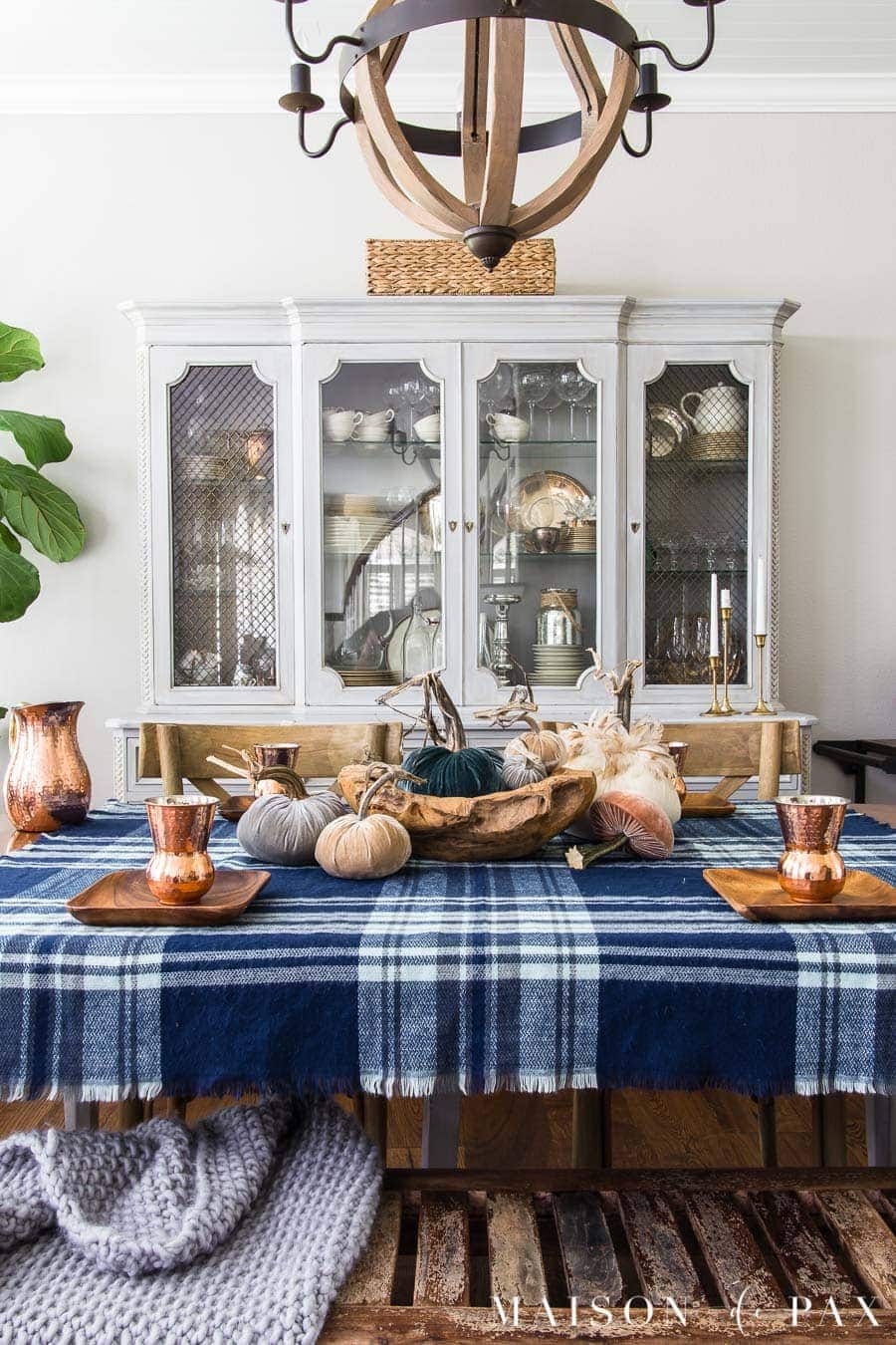 Thanksgiving table centerpieces with blue plaid tablecloth, acaia bread bowl and mini pumpkins