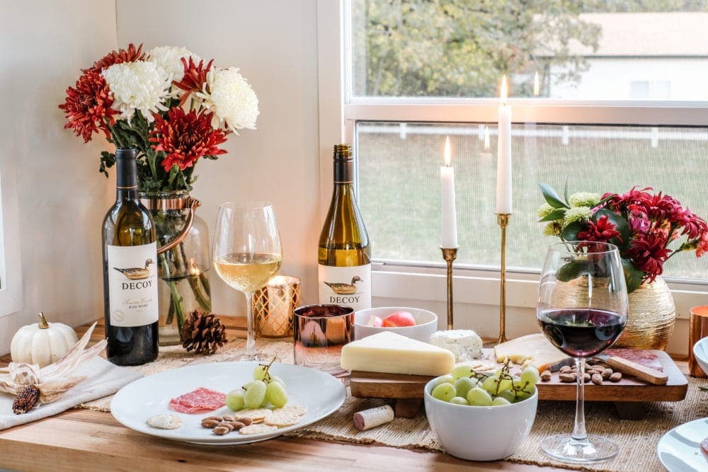 thanksgiving table setting with wine, cheese and candles 