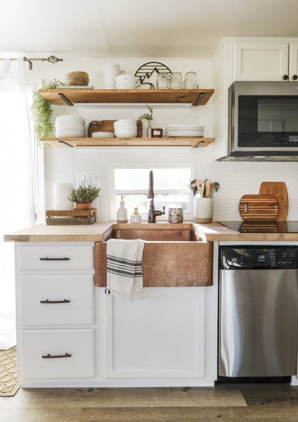 RV kitchen remodel with white cabinets, butcher block counter tops, open shelving and a copper sink