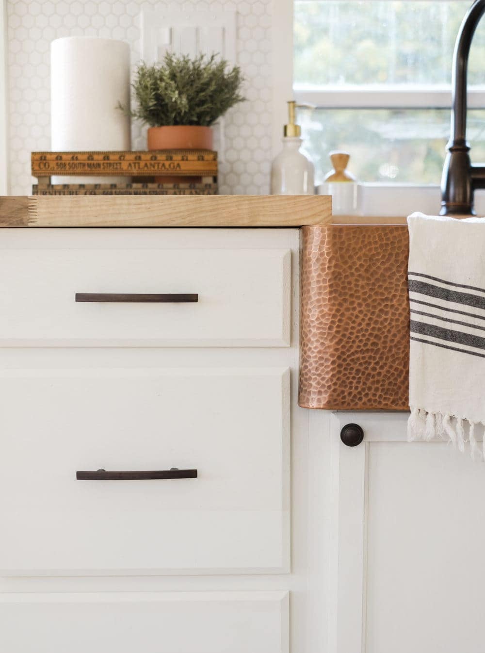 Closeup of cabinet hardware and copper sink