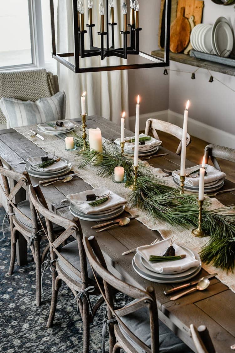 Farmhouse Christmas table centerpiece with jute runner, garland and brass candlesticks