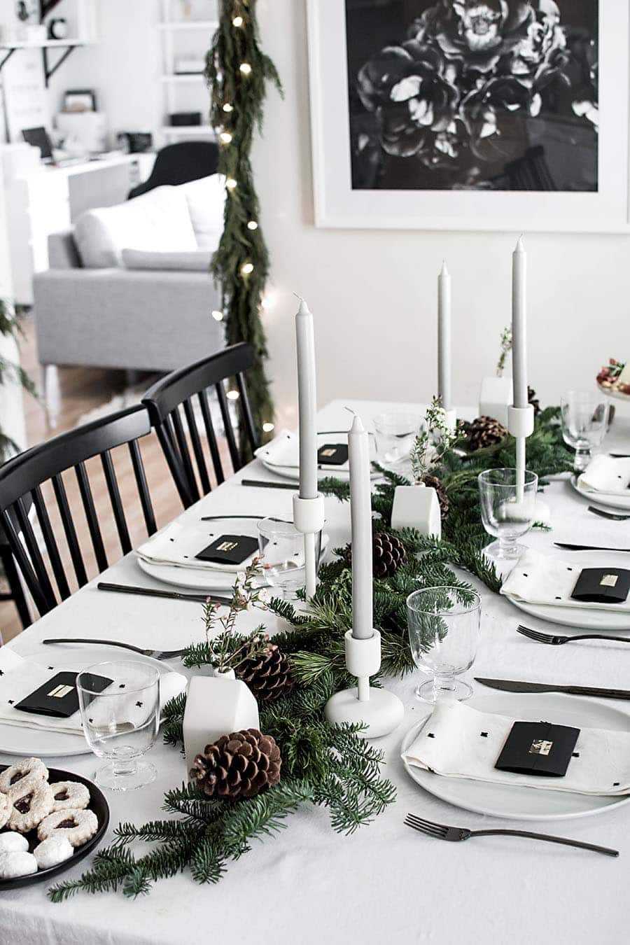 Black and white christmas table decorations using candles and green garland