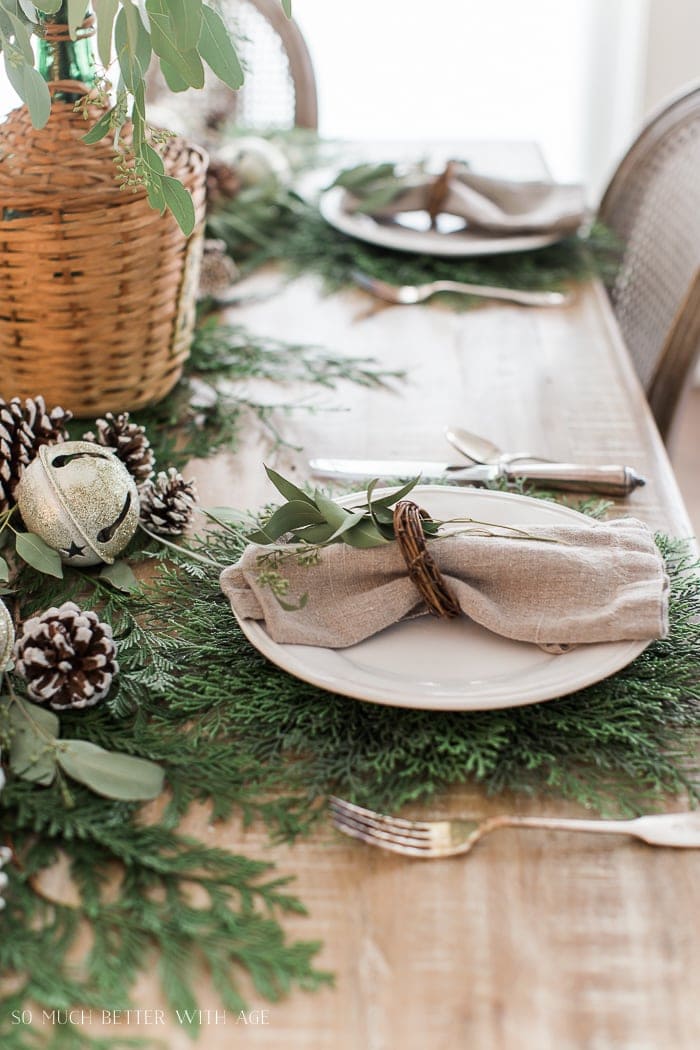 Christmas table setting with cedar chargers and mini wreath napkin rings