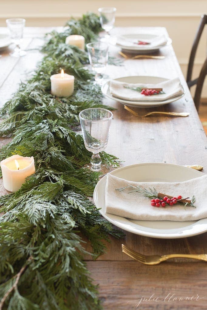 Simple christmas table setting ideas using holly berries, folded napkins and cinnamon sticks