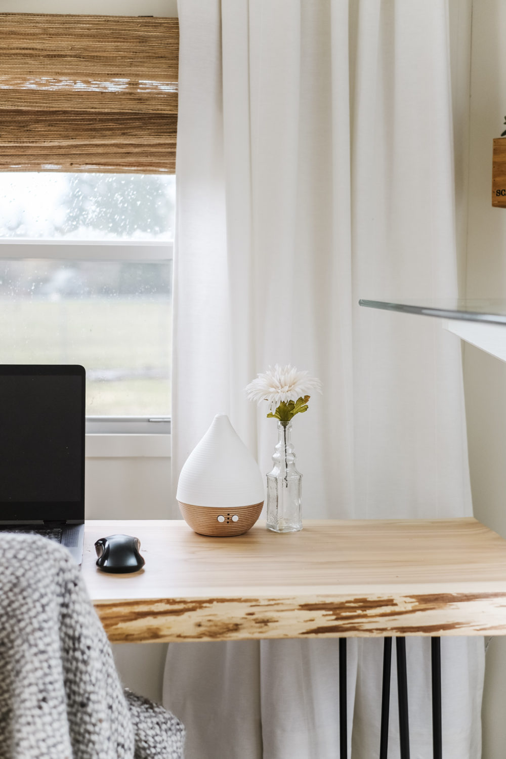 Modern oil diffuser and small vase on top of wood desk