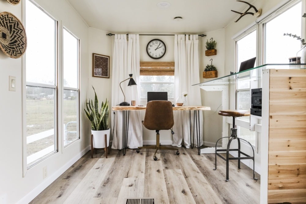 Home office inspiration with white curtains, wood desks and two workstations 