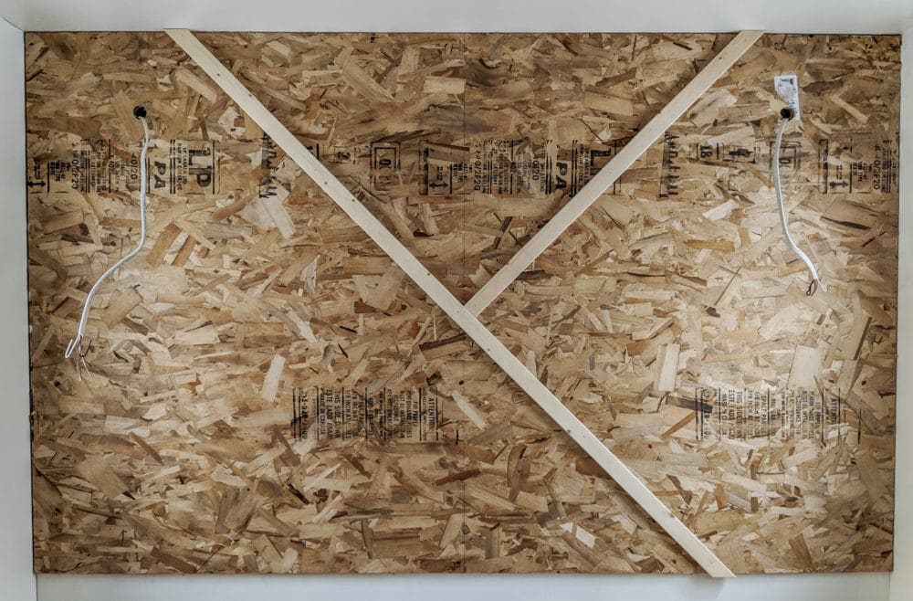 Modern wood wall with first pieces of wood nailed to plywood backer