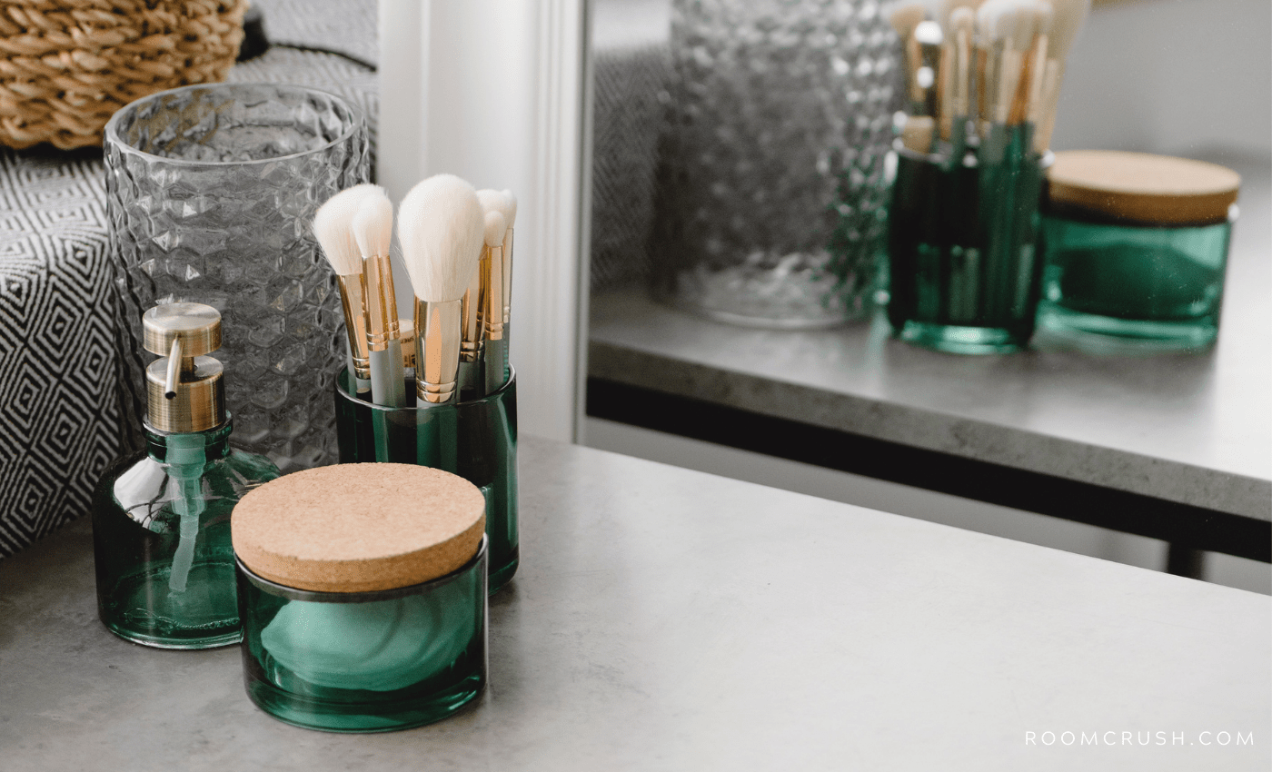 Must-Have Powder Room Accessories on a counter reflected in a mirror