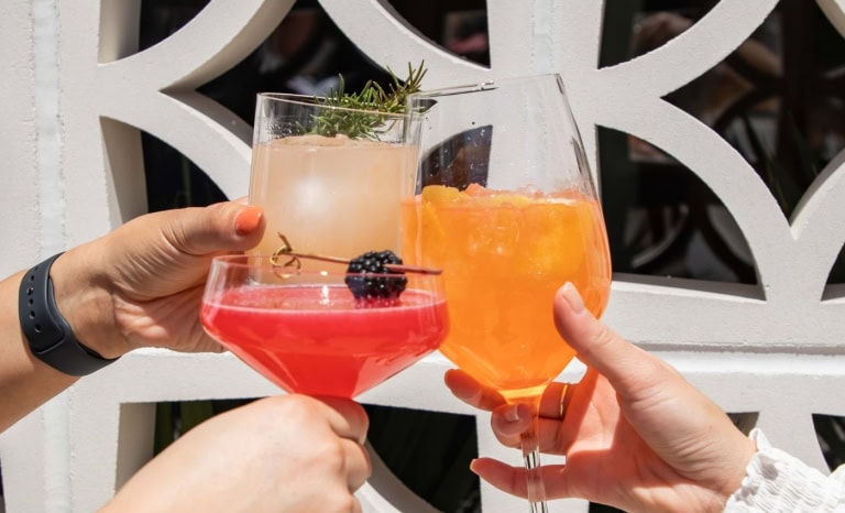 3 friends hold up 3 glasses of Summer Drink Recipes That Always Impress