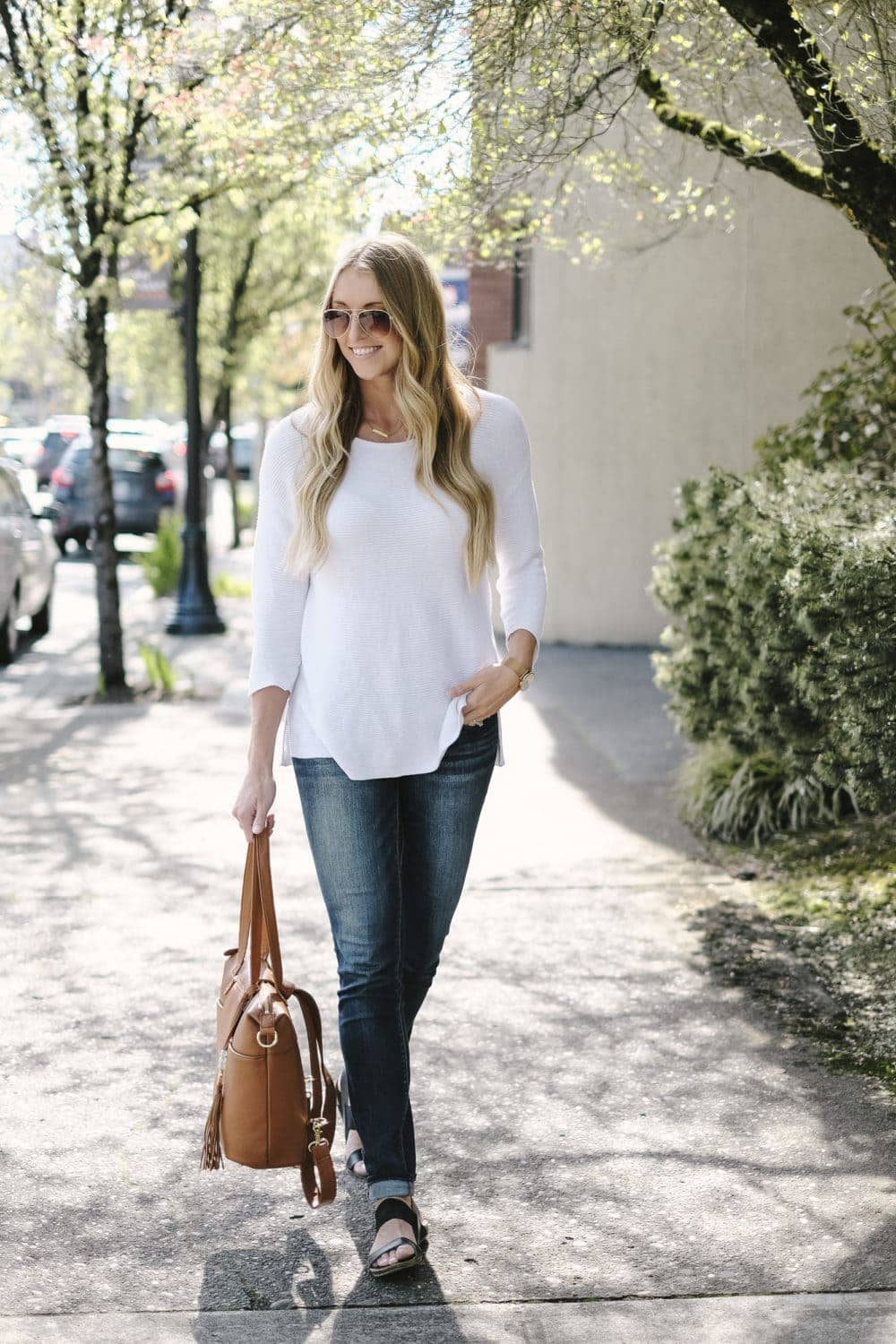 blonde woman holding lily jade diaper bag in camel leather