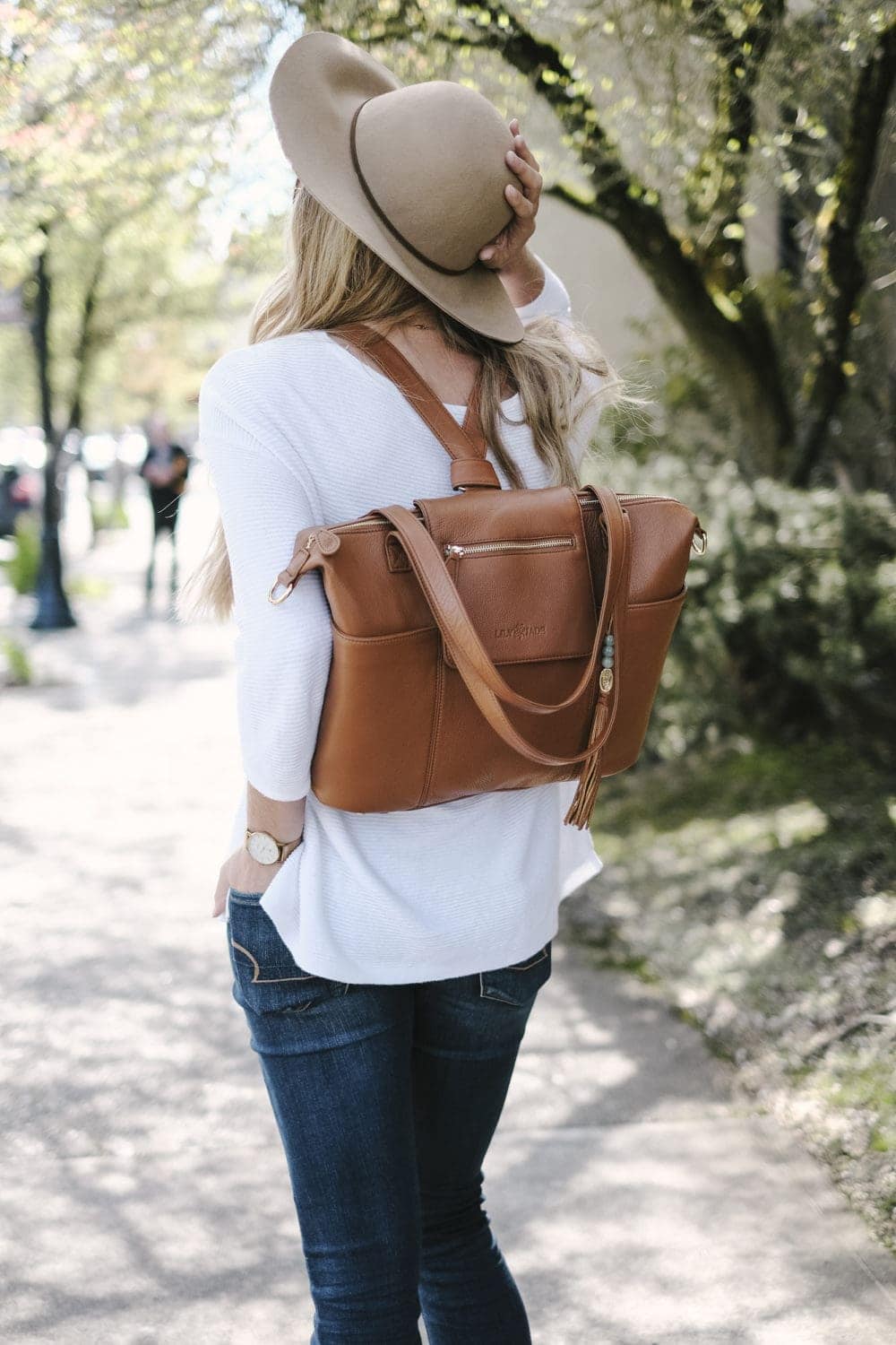 lily jade diaper bag in camel leather worn as a backpack