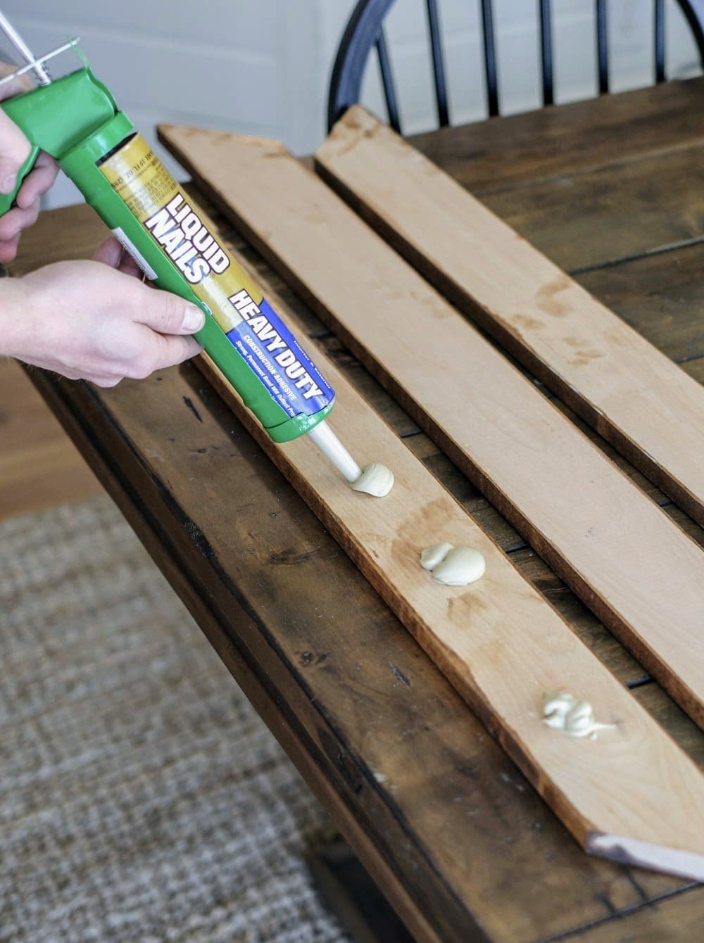 applying adhesive to bathroom mirror frame boards