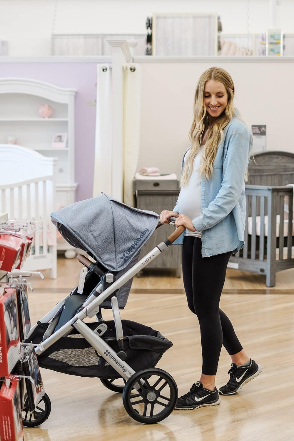 blonde woman pushing stroller in store