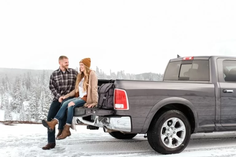 couple sits in truck enjoying holiday road trip