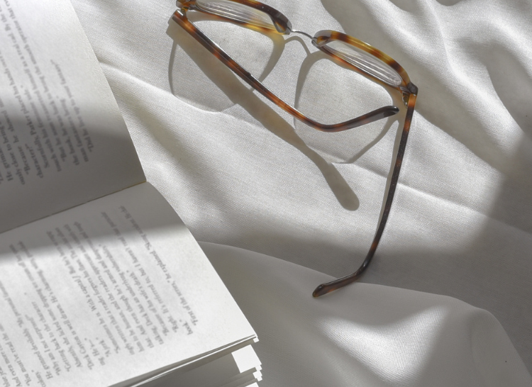 glasses and book showing how to have a staycation at home