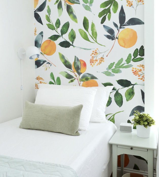 removable wallpaper with a peach and leaf print behind a bed