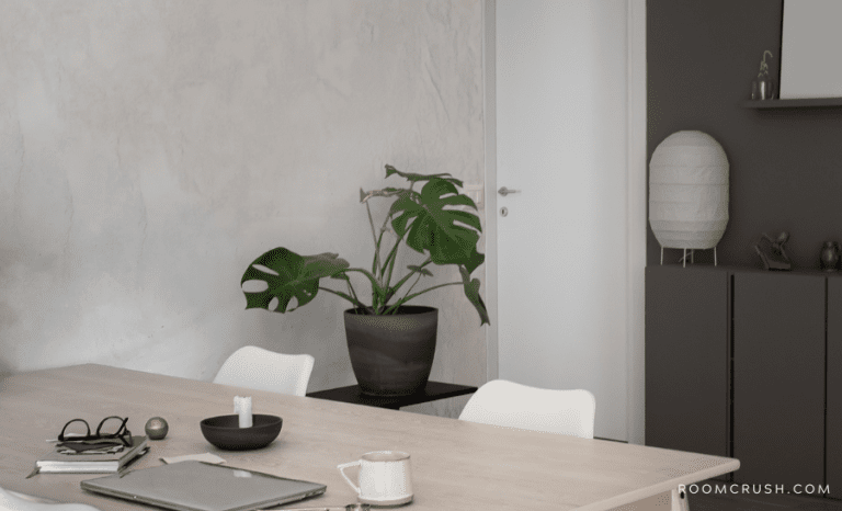 A desk, lamp, and houseplant showing how to decorate an apartment