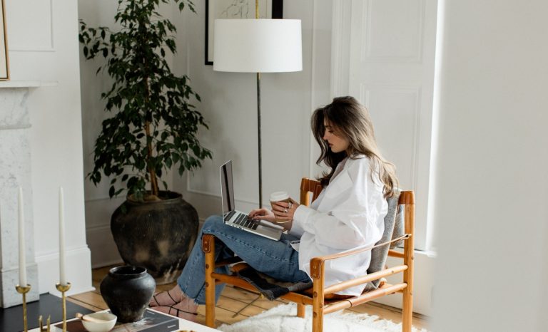 woman sits in her apartment learning about the Best Paint Colors For South Facing Rooms at roomcrush