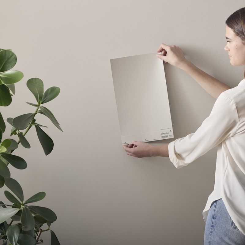 woman holding up a vinyl peel-and-stick paint color sample 