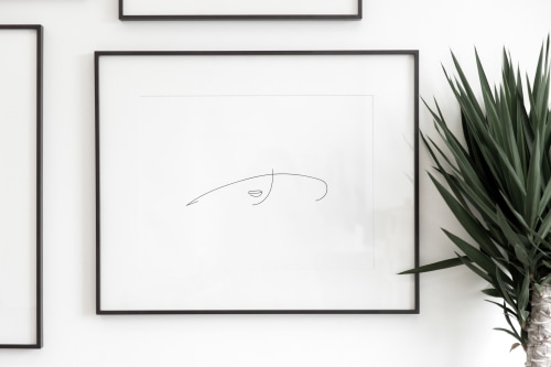 Minimalist wall art and a small plant are great ways to decorate a house on a low budget